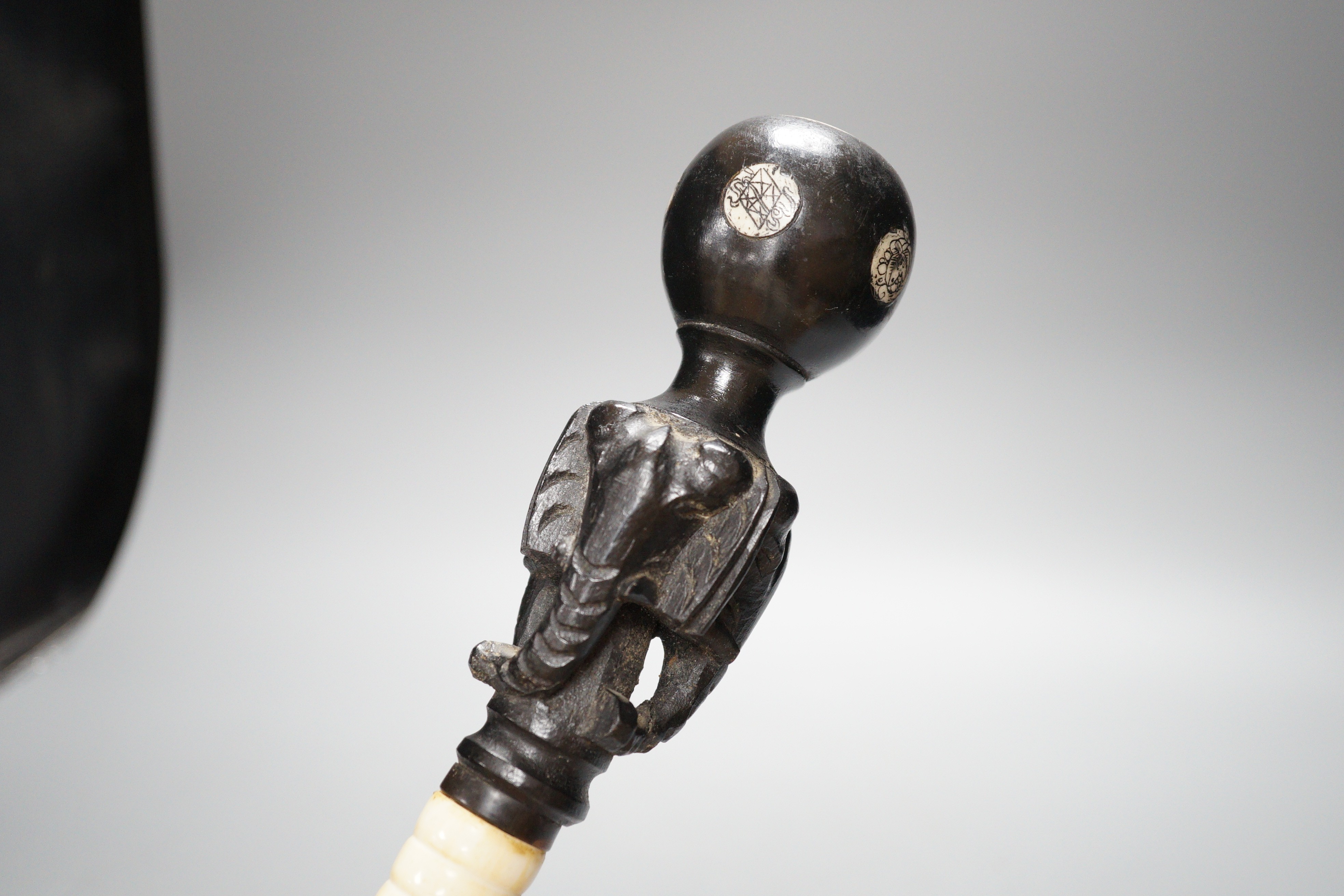 A south East Asian engraved bone and a carved ebony walking cane